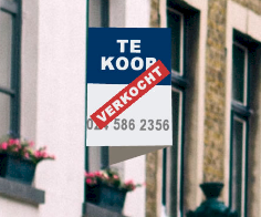 Bord 'te koop' hangend aan een gevel. Jammer, huis is verkocht.